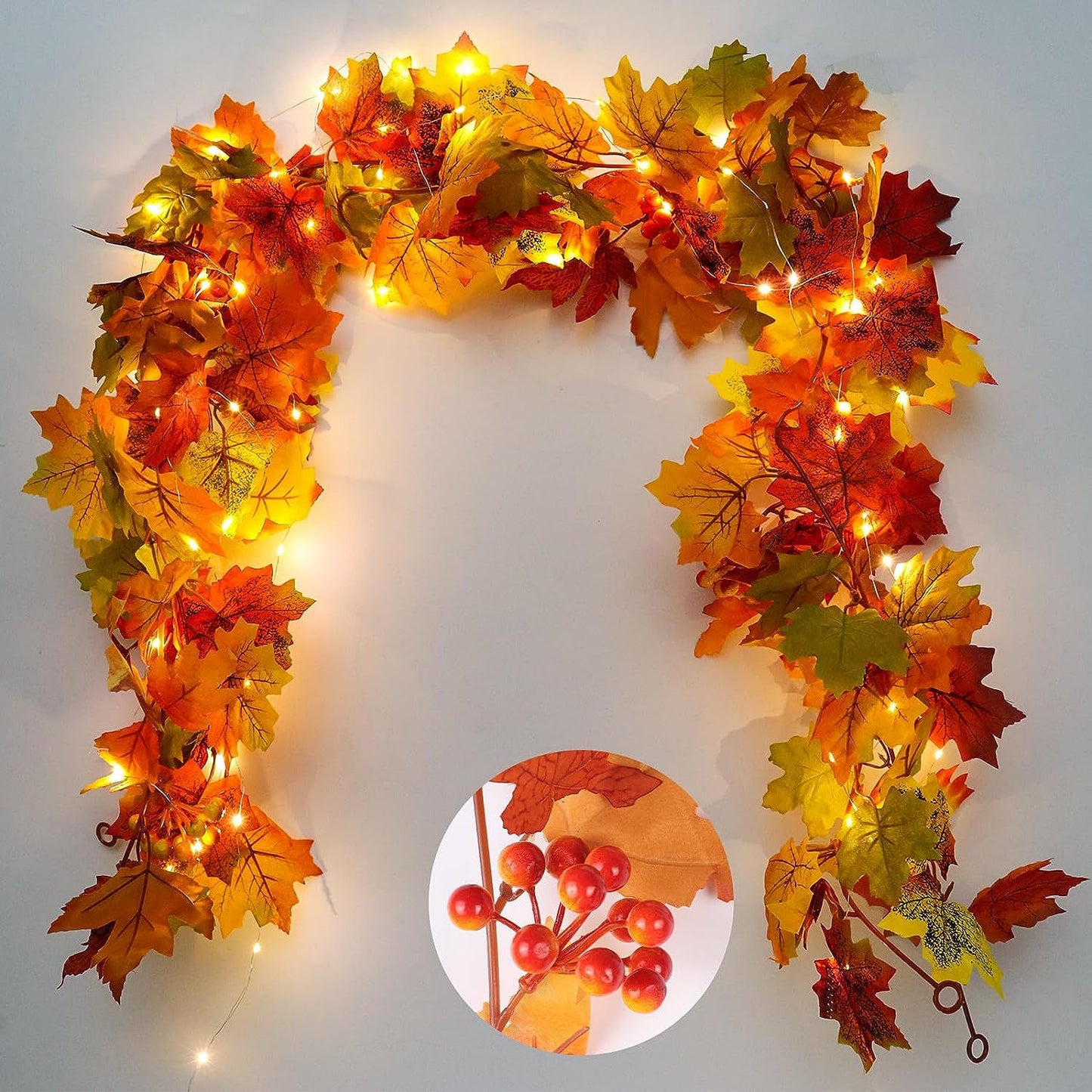 Decorative wreath with autumn leaves and lights on a plain background