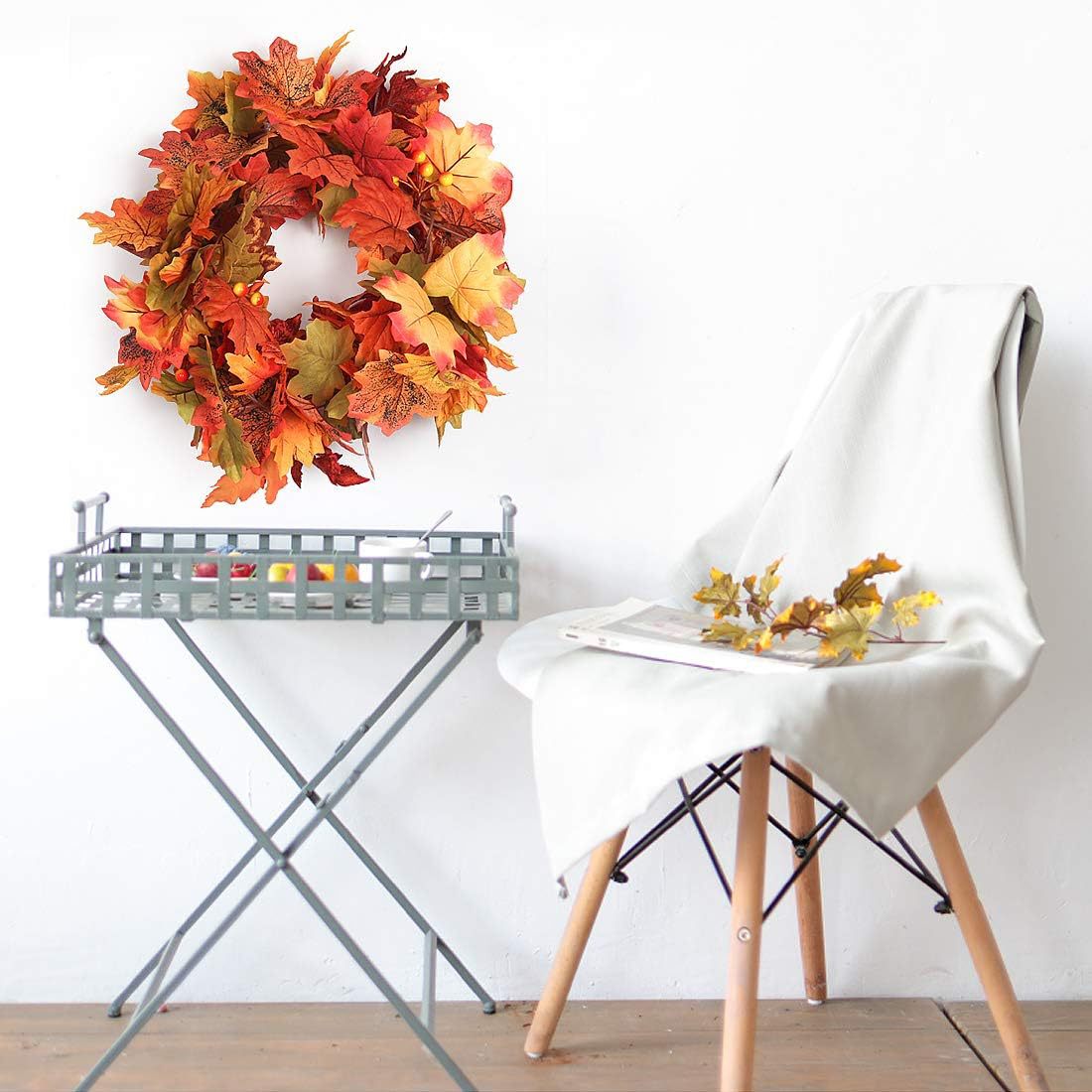 Autumn leaf wreath on a stand with a chair and small table in the background