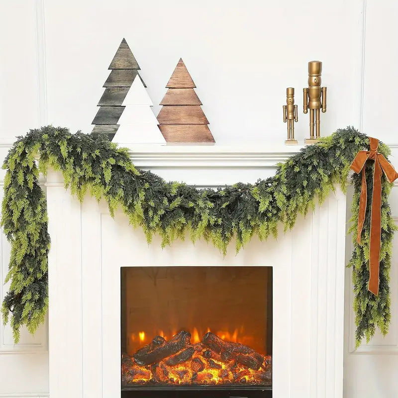 Decorative fireplace mantel with green garland, wooden trees, and a nutcracker.