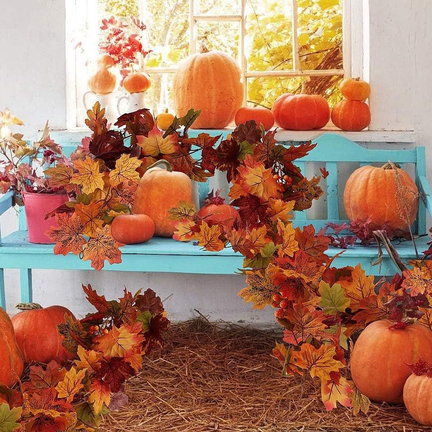Autumn decorations with pumpkins and leaves on a blue bench.