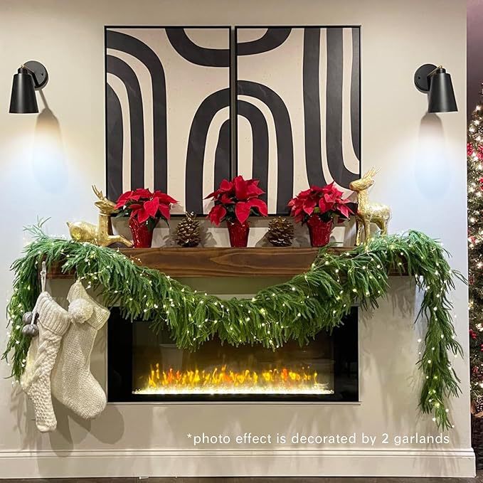 Decorated Christmas mantel with garlands, stockings, and potted plants against a wall with abstract patterns.