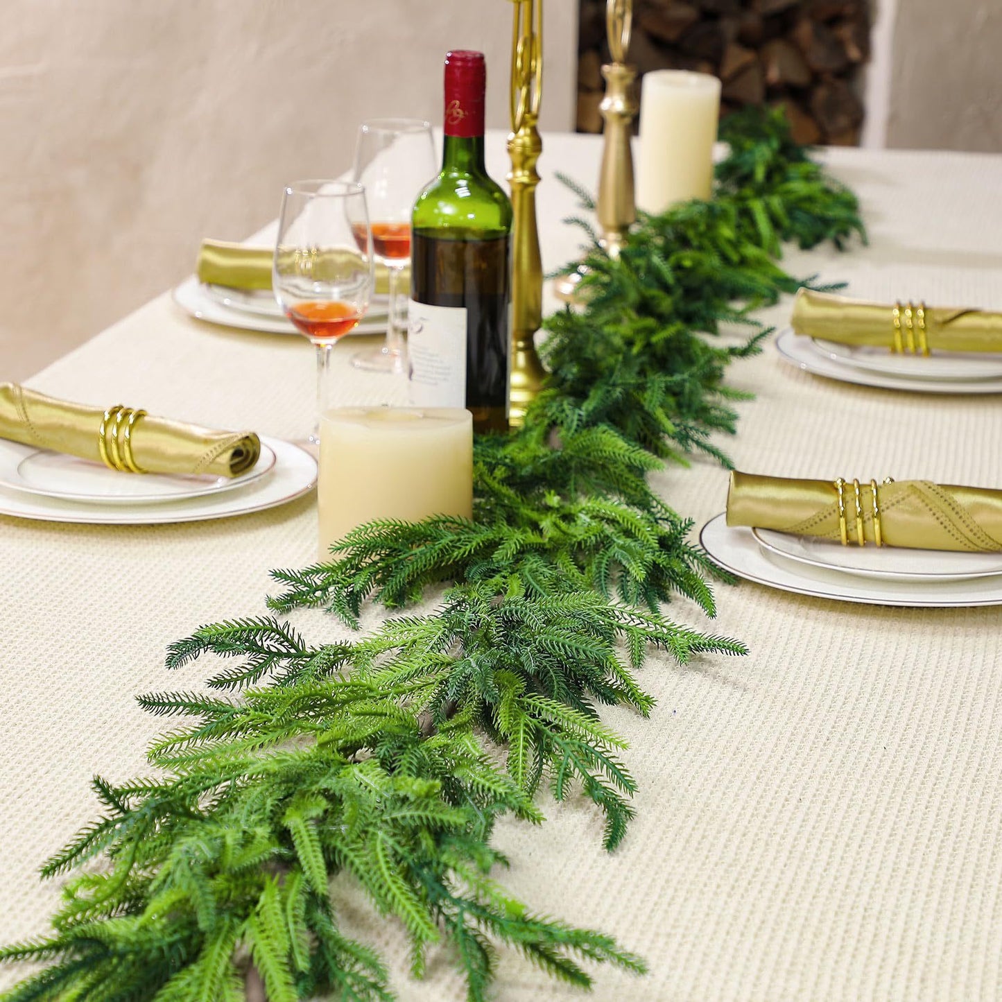 Decorative table setting with greenery, wine, and gold accents.