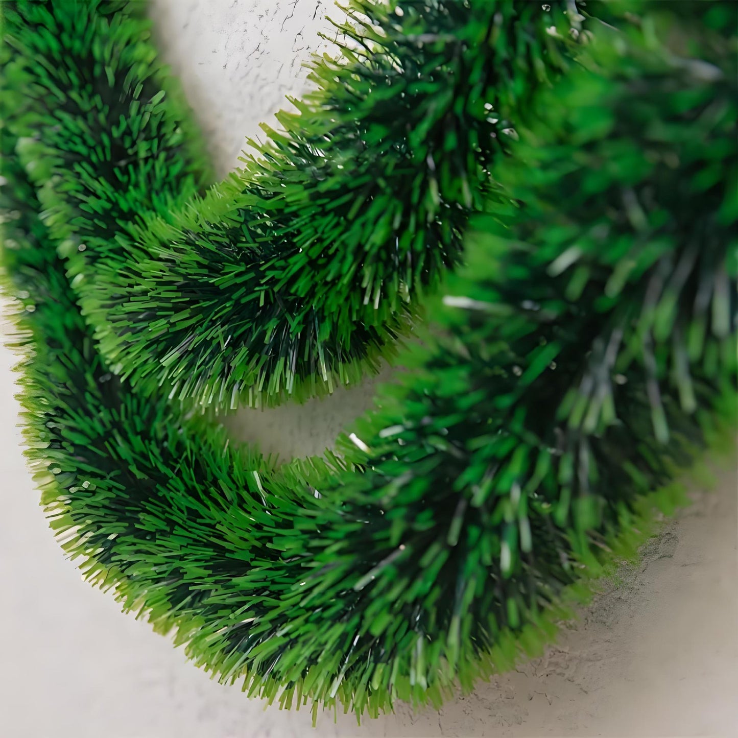 Close-up of a green artificial wreath on a white background