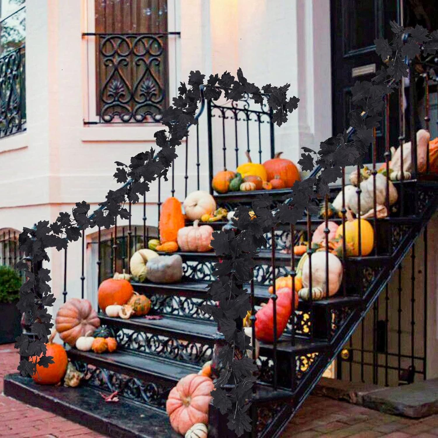 Decorative Halloween setup with pumpkins on a staircase in front of a building.