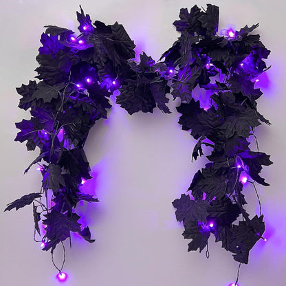 Decorative wreath with black leaves and purple LED lights on a white background