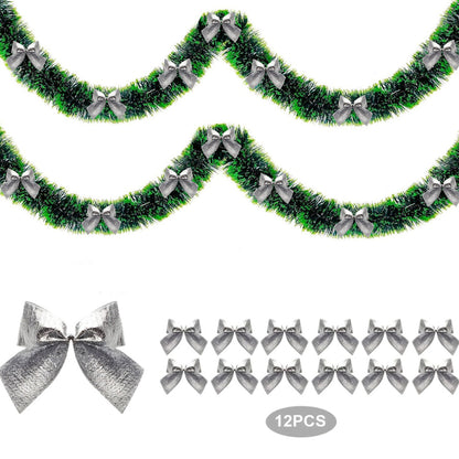 Green tinsel garland with silver bows on a white background