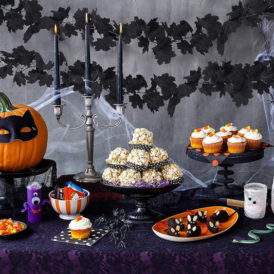 Halloween-themed table setting with popcorn tower, pumpkins, and decorative elements.