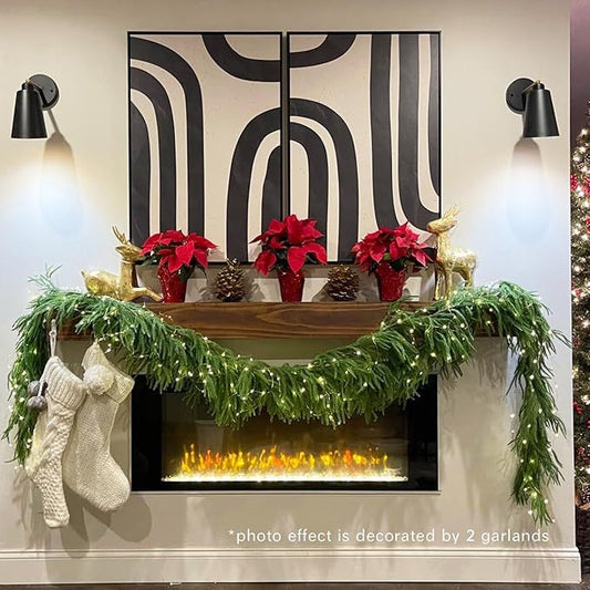 Decorated Christmas mantel with garlands, stockings, and potted plants against a wall with abstract patterns.