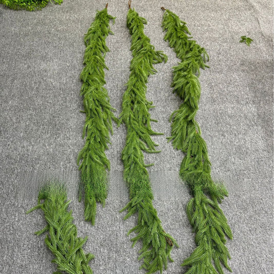 Set of green artificial garlands on a textured gray surface
